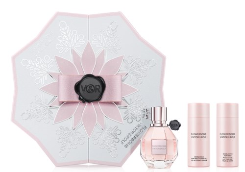Ett parfympresentset med en rosa rosett, blommönster, parfymflaska och två rosa behållare.