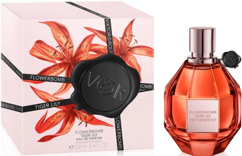 A perfume bottle with a flower design, box features tiger lily flowers and black ribbon. The bottle is rose-colored.