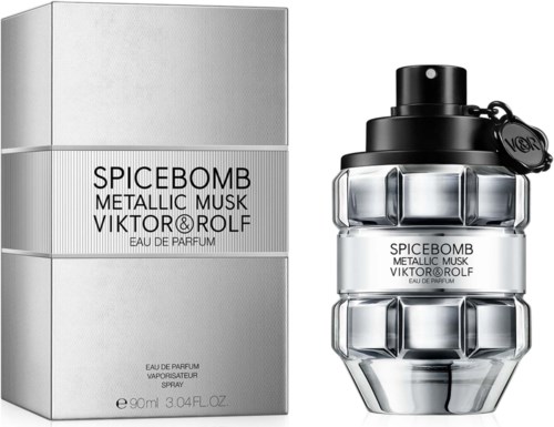 En doftflaska formad som en granat, med silver och svart design bredvid dess förpackning. Förpackningen har parfymens namn.