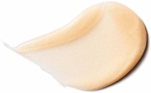 En drop av beige concealer på svart bakgrund.