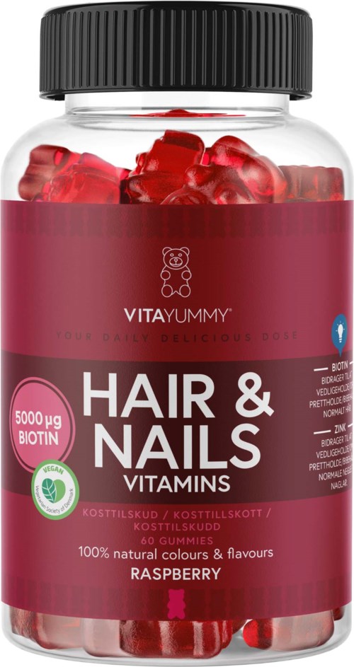 Röd hallonsmakande gelébitar i en klar flaska med svart lock, märkt för vitaminer för hår och naglar.