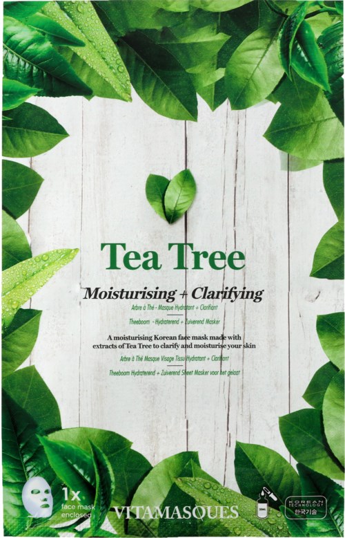 Grønne blader omgir en hvit trebakgrunn med tekst om et ansiktsmaskeprodukt med tea tree.