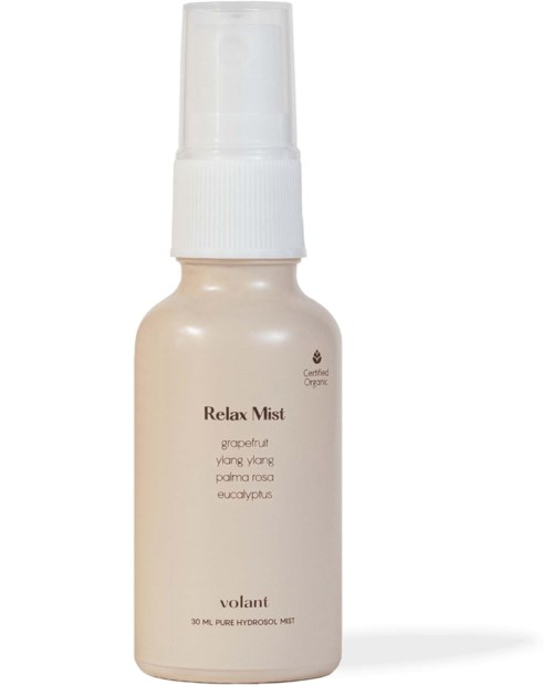 A white spray bottle labeled 'Relax Mist' with ingredients like grapefruit and eucalyptus, designed for soothing use.