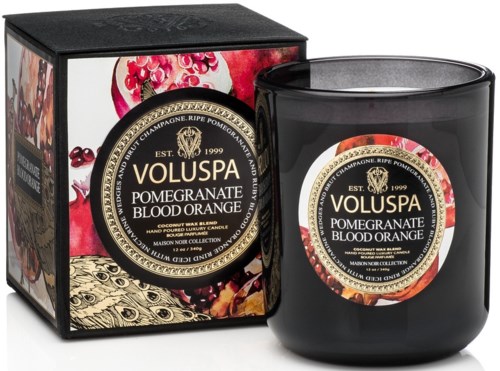 En svart ljuslykta märkt "Granatäpple Blodapelsin" bredvid en dekoration med granatäpplebilder.