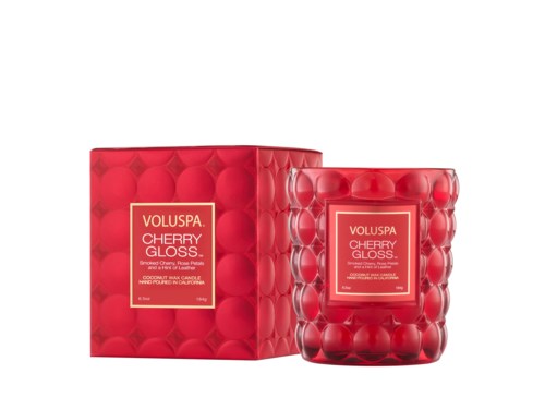 A red cherry-scented candle in a decorative glass holder with a matching box.