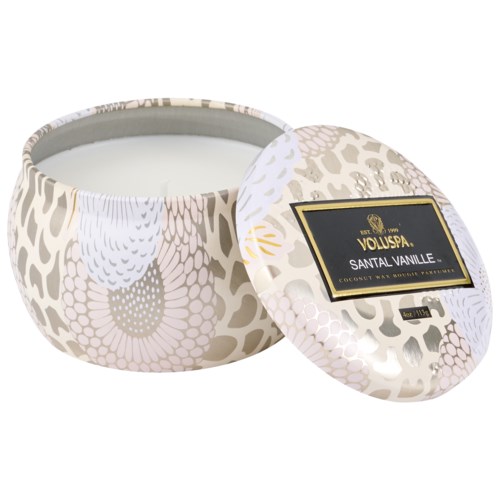 Ronde, witte en gouden versierde kaarsenhouder met een label dat zegt "Santal Vanille".