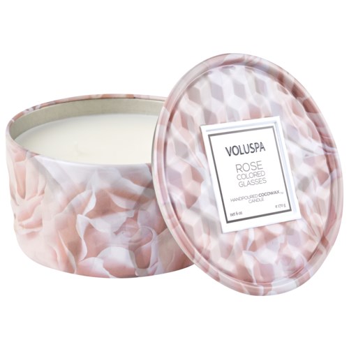 Ett rosa och vitt marmorerat doftljus i en rund behållare med lock. Etiketten säger "Voluspa" och "Rose".