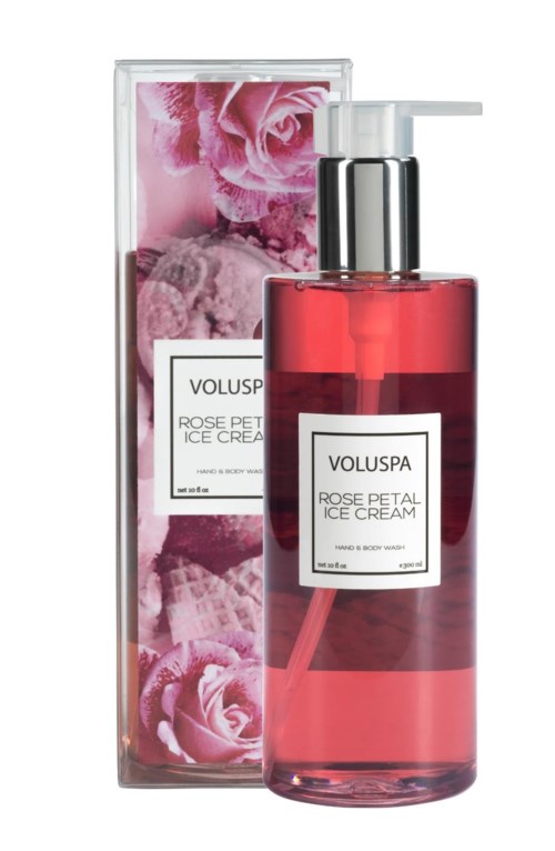 En rosa flaska med pump bredvid en box med rosa rosor och blad, märkt 'Voluspa Rose Petal Ice Cream'.