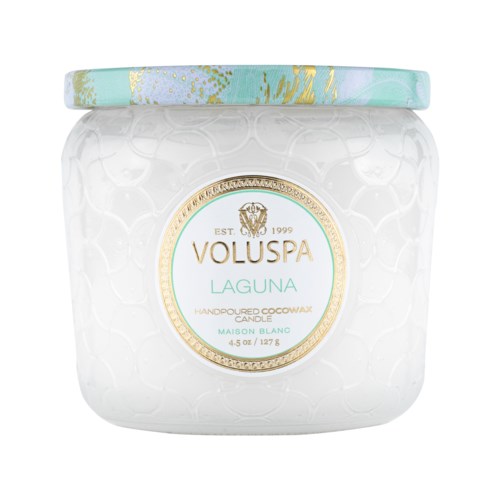 A white candle jar with a gold and green label. The label says 'Voluspa Laguna' and 'Handpainted Cowbox Candle.'