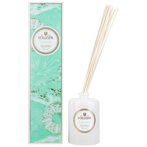 A white vase with incense sticks and a tall, colorful box with a floral design and label.