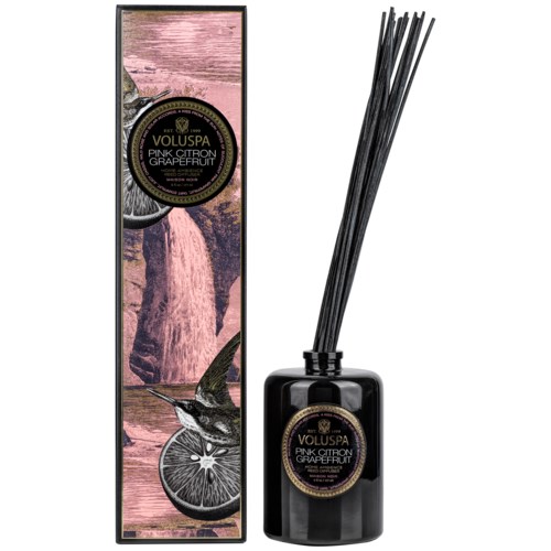 En svart doftpinnar med doft av pink citron och grapefrukt, bredvid sin dekorerade förpackning med rosa och svart design.