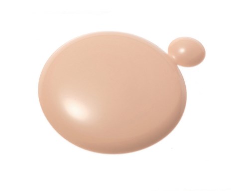 A beige makeup sponge with a small round handle on top.