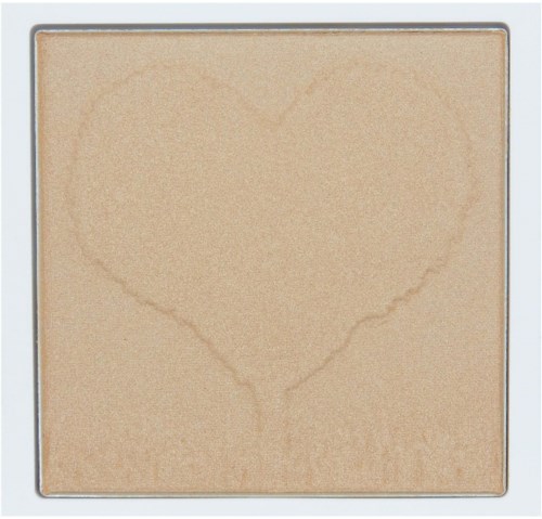 En beige sminke puder i en kvadratisk kompakt med et subtilt hjerteformet avtrykk på overflaten.