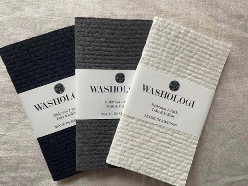 Three folded cloths in black, gray, and white with labels from Washologi, made in Sweden.