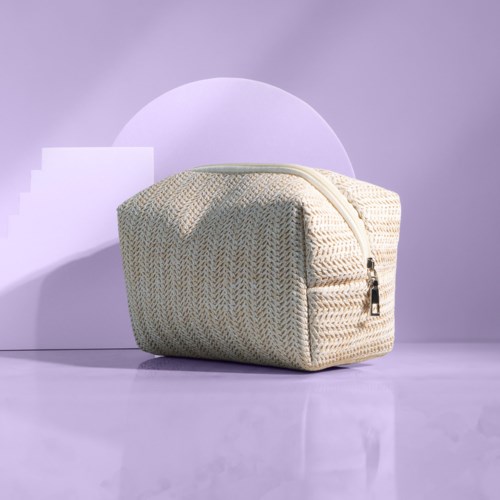 A beige fabric bag with a zipper, placed on a purple surface with geometric shapes in the background.