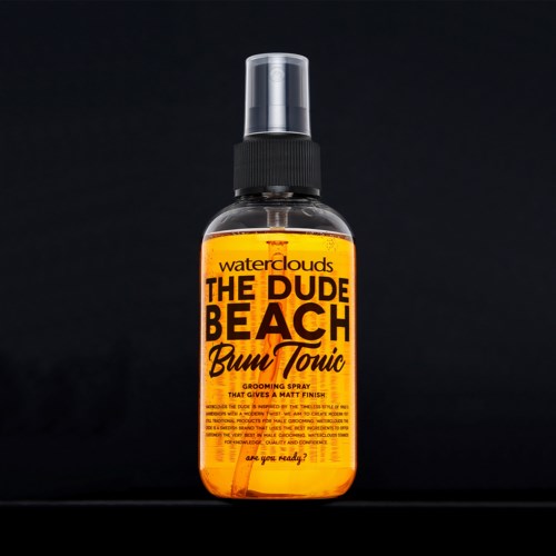 Butelka spray z pomarańczową etykietą, na której napisano 'The Dude Beach Bum Tonic' i 'grooming spray for a matte finish.'