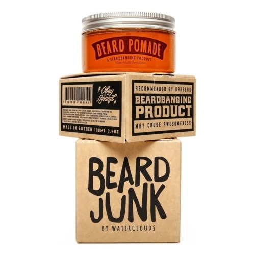 Een pot baardpomade, een kartonnen doos met baardverzorging, en een papieren tas met 'BEARD JUNK'-tekst.