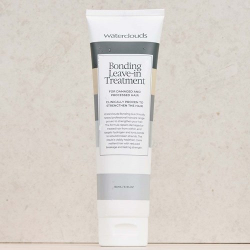 En vit tub av Waterclouds Bonding Leave-in Treatment för skadat, behandlat hår, med svart och vit text, på en beige bakgrund.