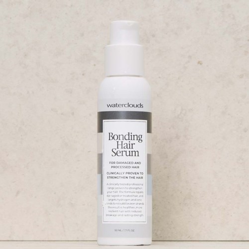 En vit flaska med pump märkt 'Bonding Hair Serum' från Waterclouds står mot en enkel bakgrund.