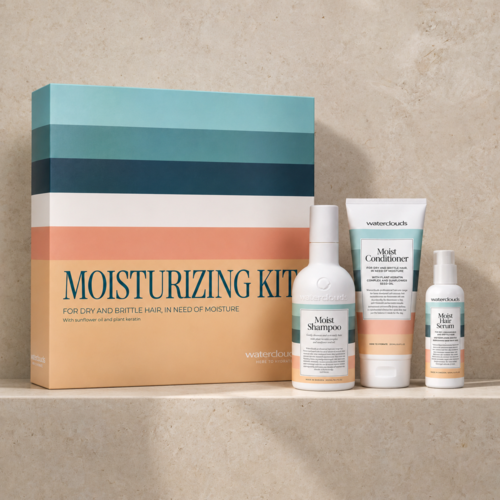 Sæt af fugtgivende produkter til hår og hud med en farverig æske mærket Moisturizing Kit. Indeholder shampoo, balsam og serum.