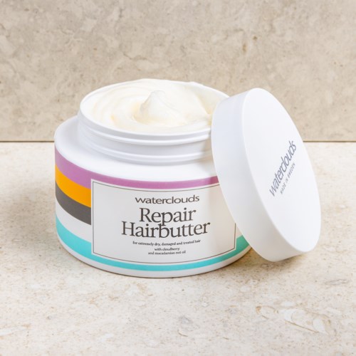 En burk av waterclouds Repair Hairbutter med locket öppet, visar vit kräm inuti.