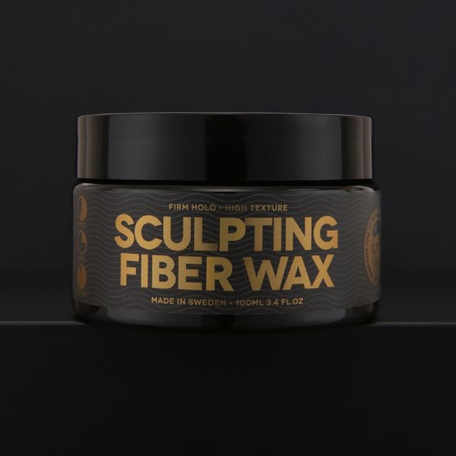 En sort beholder med guld tekst siger 'Sculpting Fiber Wax', lavet i Sverige, 100 ml, til hårstyling.