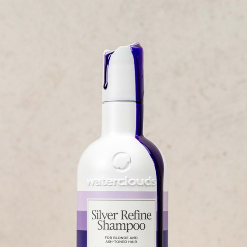 En hvit sjampo-flaske med lilla kork og etikett som sier 'Silver Refine Shampoo'.