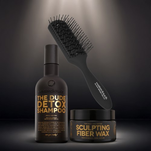 En sort flaske med detox-shampoo, en rund beholder med sculpting fiber voks, og en hårbørste med buet design.