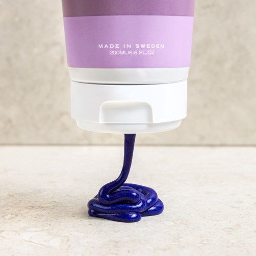 En tub märkta 'Made in Sweden' släpper ut mörkblå gel på en yta.