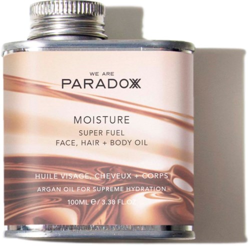 A metal bottle of PARADOX moisture super fuel face, hair, and body oil with a pink and brown label.