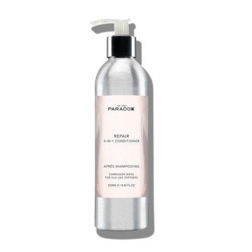 A silver bottle with a pump, labeled 'Repair 3-in-1 Conditioner' for hair care, with a pink and white label.