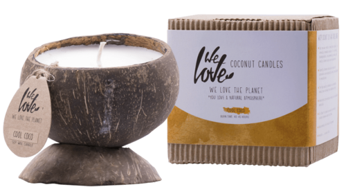 Ett kokosformigt ljus med veke, bredvid en låda märkt 'Coconut Candles' från Wet Love, med miljövänlig förpackning.