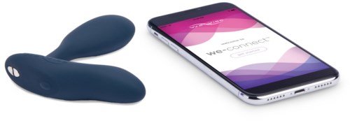 Ein Smartphone verbunden mit einem kleinen dunkelblauen Gerät, wahrscheinlich zur Gesundheitsüberwachung, auf einer weißen Oberfläche.