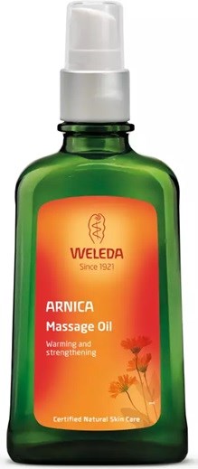Green bottle with orange label, labeled Weleda Arnica Massage Oil, used for warming and strengthening muscles.