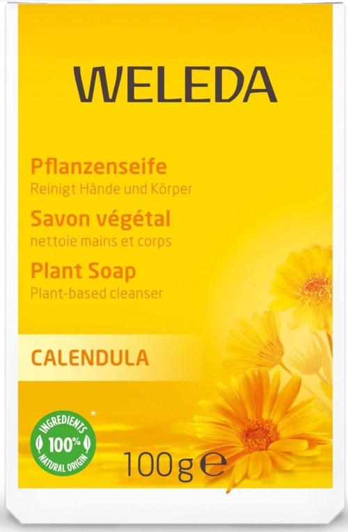 Förpackning i gult för växtbaserad tvål med blommor och en grön etikett, flera språk och 100 g.