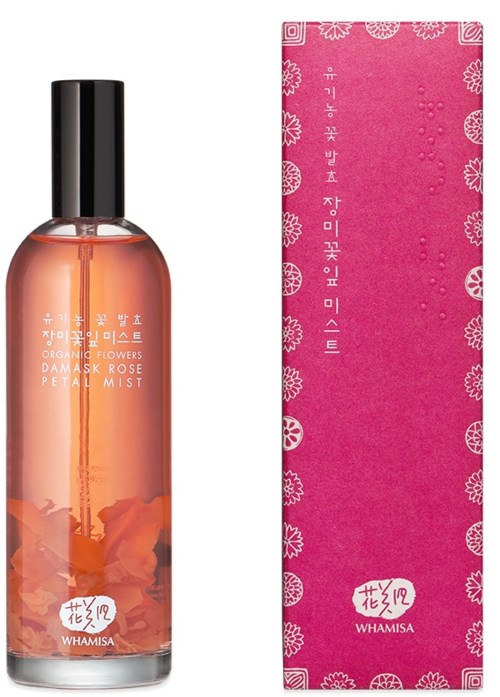 En rosdoftande dimma i en klar flaska med svart lock, bredvid en rosa låda med blommönster och koreansk text.