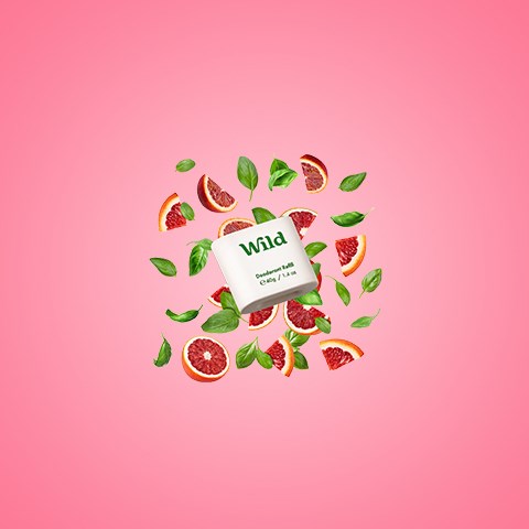 Vilhalaatikko, jolla lukee 'Wild', ympärillä greipin lohkoja ja mintunlehtiä vaaleanpunaisella taustalla.