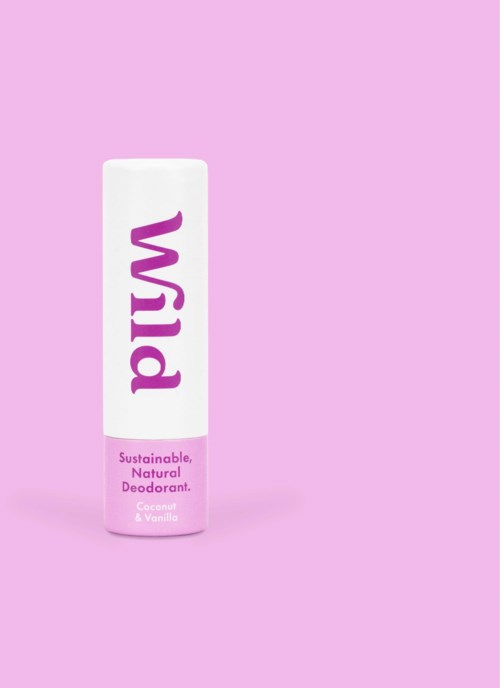 A white deodorant stick with purple and pink text on a pink background. The label says "Wild" and mentions coconut & vanilla.