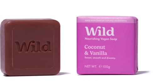 Suklaalevy ja vaaleanpunainen saippuakotelo, jossa lukee 'Wild Coconut & Vanilla'. Saippua on vegaani ja ravitseva.