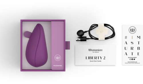 Ein lila persönlicher Masseur, Ladegerät, Schnellstartanleitung und ein Sehtest mit Womanizer-Logo auf weißem Hintergrund.