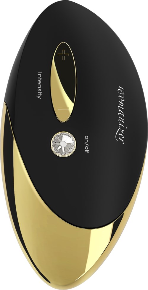 En svart och guld elektronisk enhet med knappar för intensitet och av/på-knapp. Den har en slank, oval form.