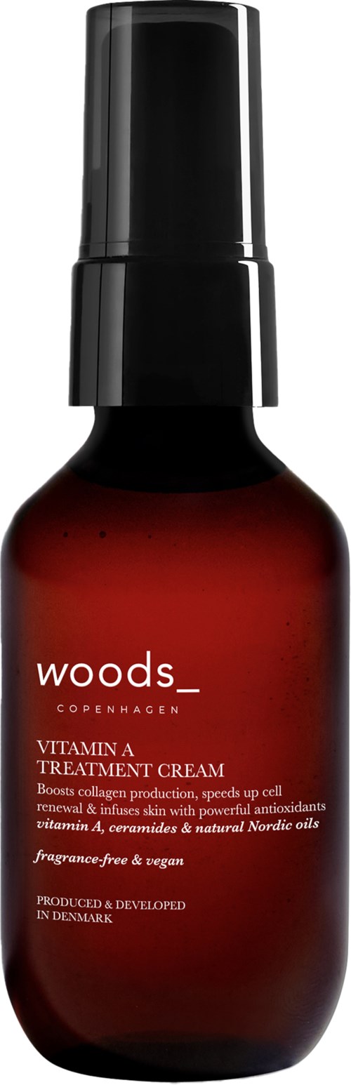 A dark amber bottle with a black spray cap, labeled Woods Copenhagen Vitamin A Treatment Cream, without fragrance or parabens.