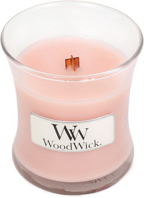 A pink scented candle in a glass jar with a WoodWick logo and a wooden wick.