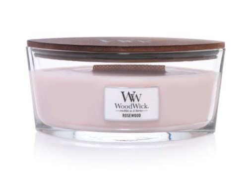 A pink candle in a clear glass container with a wooden lid, labeled 'WoodWick Rosewood.'