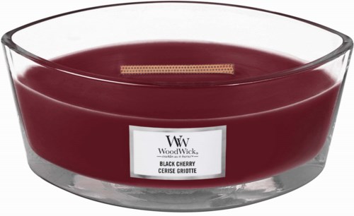 En mörkröd ljus i ett transparent glas med en etikett, märkt som Black Cherry doft.