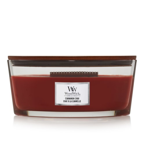 A large, rectangular candle in a glass container with a cinnamon chai scent label. The candle is a reddish color.