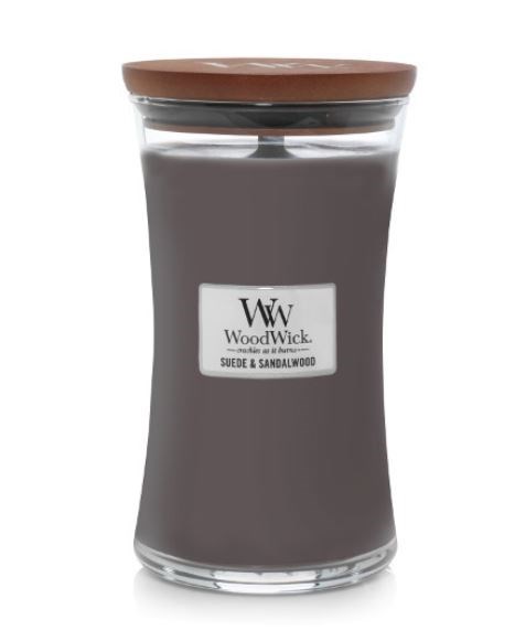 Et gråt stearinlys med træsvaje i et glas med brunt låg og sort label. Mærket er WoodWick.
