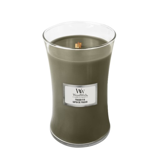 En stor grön doftljus i glasbehållare, märkt med WoodWick och doftnamn.
