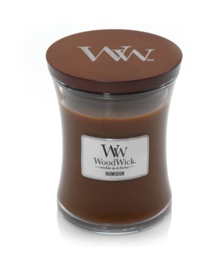 Ruskea tuoksukynttilä lasipurkissa, jossa on puululka ja etiketti, jossa lukee "WoodWick" ja "Humidor."
