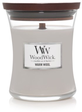 Et hvitt lys i et glasskrukke med trelokk, merket 'Warm Wool' av WoodWick, med en voks inni.